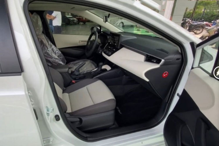 Bên cạnh đó, Toyota Corolla XLi 2022 chỉ có điều hòa chỉnh cơ, ghế ngồi bọc nỉ sáng màu chỉnh cơ, ghế sau không có bệ tỳ tay nhưng được bổ sung cửa gió điều hòa. Những tiện nghi khác của xe cũng rất nghèo nàn như: gạt mưa gián đoạn, chìa khóa, phanh tay cơ và bảng đồng hồ sau vô-lăng cũng tương tự.