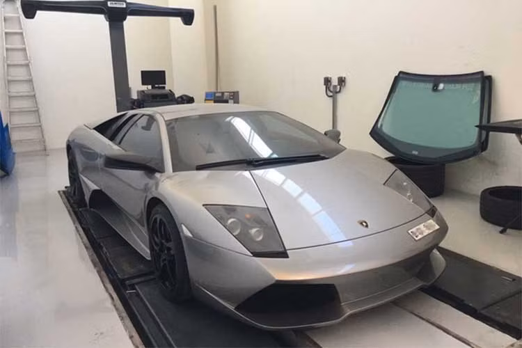 Một chiếc Lamborghini Murcielago màu xám đang được thay lốp tại đây.