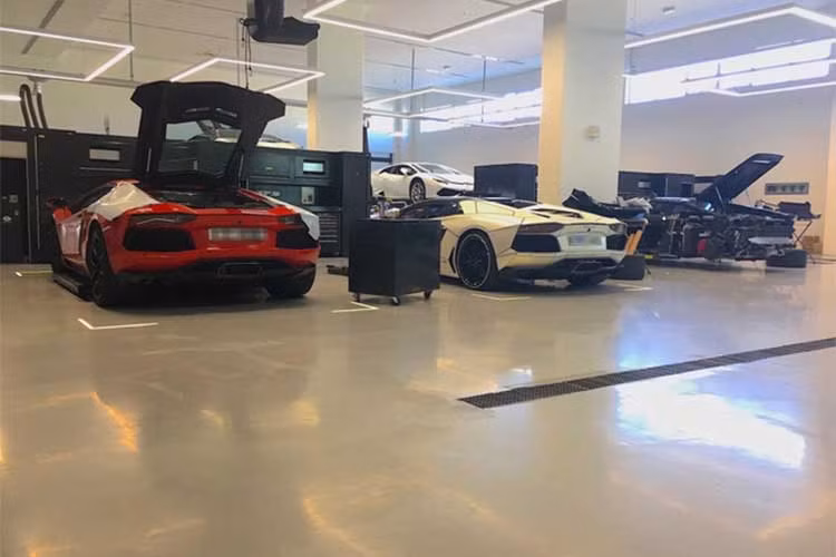 Khác với showroom, một khu vực khác luôn đầy ắp siêu xe của hãng này là khu vực bão dưỡng. Hai chiếc Lamborghini Aventador và Lamborghini Huracan của khách hàng gửi tại đây đã được tháo rời phần cản sau.