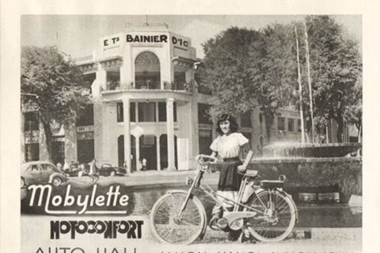 Mẫu quảng cáo cho xe đạp máy Motoconfort có hậu cảnh là đài phun nước ở đại lộ Charne, nay là đại lộ Nguyễn Huệ tại TP HCM. Mẫu xe đạp máy này thời điểm đó được dành cho các nữ sinh con nhà giàu có sử dụng. 