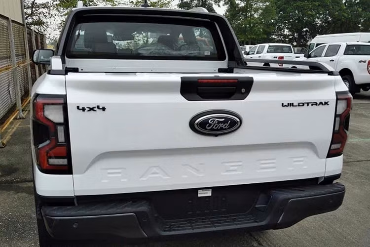 Chiếc xe bán tải Ford Ranger 2023 phủ sơn trắng thuộc phiên bản Wildtrak được trang bị đèn chiếu sáng dạng LED. Lưới tản nhiệt dạng tổ ong chứa thanh ngang dài. Điểm nhấn đặc biệt nữa là gương chiếu hậu màu đen và bộ mâm sơn màu xám tro đậm chất thể thao.