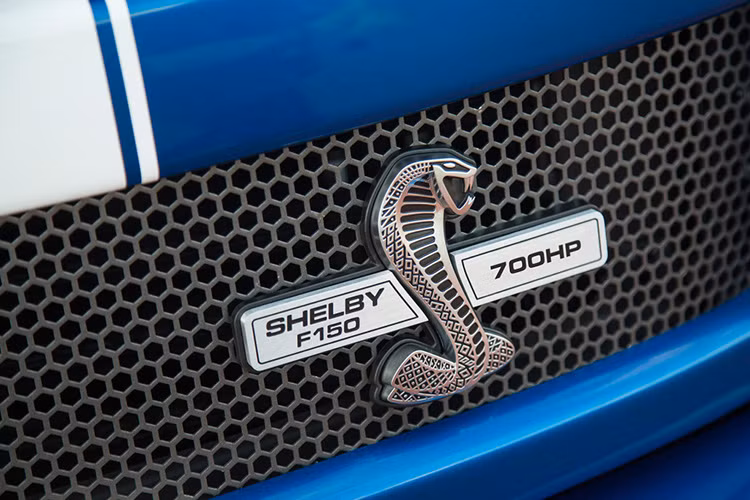 Trên lưới tản nhiệt dạng tổ ong của Shelby F-150 Blue Thunde là logo quen thuộc với biểu tượng rắn hổ mang chúa có gắn công suất 700 mã lực. 