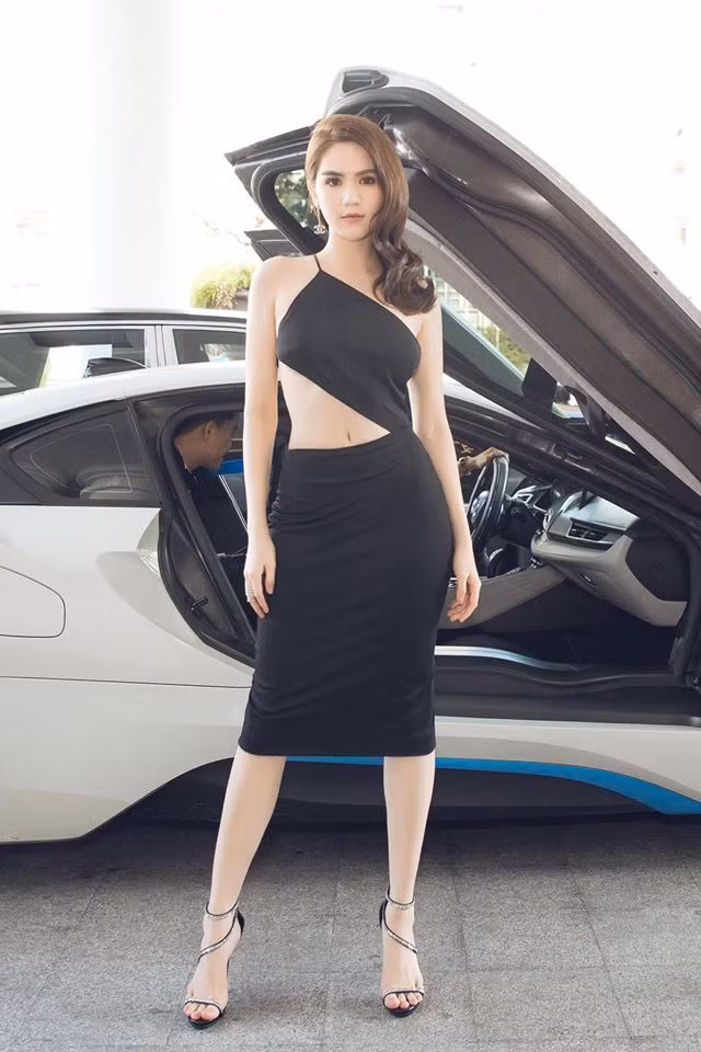 Bộ trang phục với mẫu váy cut-out, khoe vòng eo và để lộ lưng trần của cô nàng có biệt danh "nữ hoàng nội y" bên cạnh siêu xe BMW i8 tiền tỷ sau khi xuất hiện đã gây sự chú ý từ người hâm mộ cũng như cộng đồng mạng. Được biết, người đẹp đến dự sự kiện lần này nhằm ủng hộ ông bầu Khắc Tiệp cho ứng dụng gọi xe Việt.