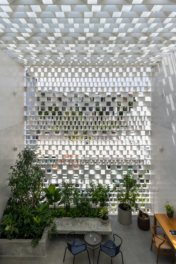 Tại mặt tiền, tấm sàn lùi vào một khoảng lớn tạo ra sân vườn ba chiều rộng rãi với khoảng giếng trời liên tục từ tầng một, kết hợp với khoảng thông tầng ở phía sau tạo lối đi cho những làn gió biển mát mẻ thổi vào nhà. Ảnh: Hiroyuki Oki