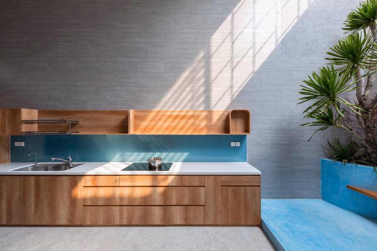 Những khoảng thông tầng phía sau - giữa nhà giúp ánh sáng tự nhiên len lỏi vào bên trong. Ảnh: Minq Bui