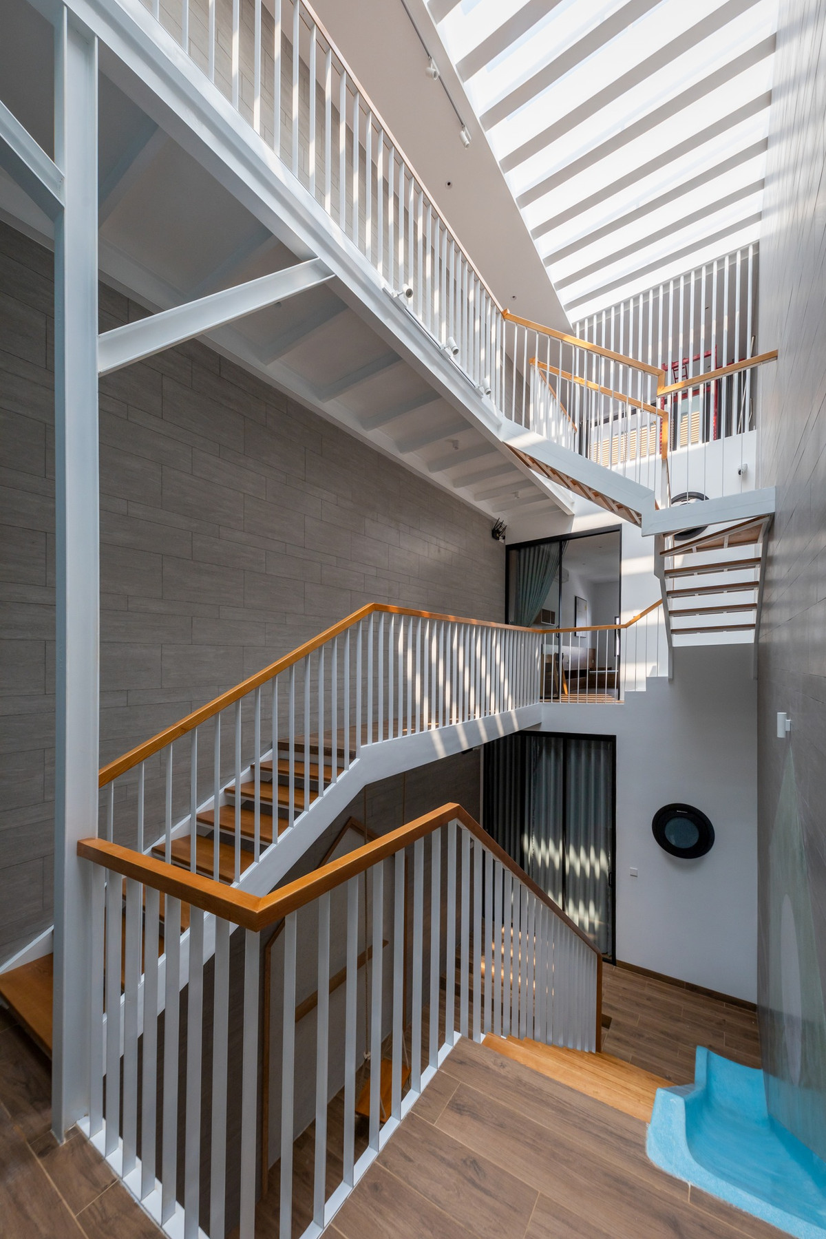 Giếng trời giúp cung cấp ánh sáng tự nhiên cho cầu thang và hành lang, góp phần tiết kiệm điện năng. Ảnh: Minq Bui