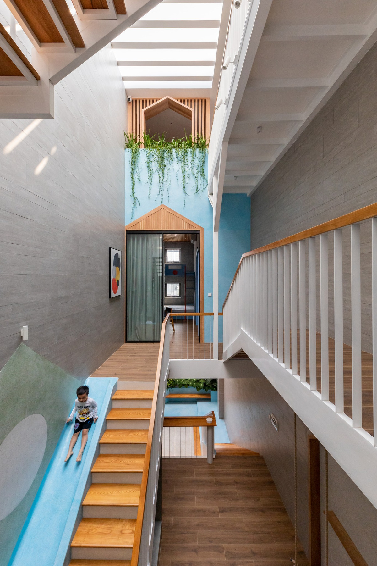 Thay vì dành diện tích cho sân trước, không gian được tối ưu hóa vào sân sau và sảnh giữa, đảm bảo khu vực vui chơi cho trẻ an toàn hơn mà không cần sự giám sát liên tục. Ảnh: Minq Bui