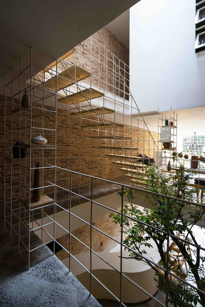 Trái ngược với những bức tường khô cứng và kín đáo, khung thép rỗng được sắp xếp tỉ mỉ theo cấu trúc bậc thang giúp bảo vệ căn nhà đồng thời cho phép ánh sáng và không khí lưu thông hiệu quả. Ảnh: Quang Dam