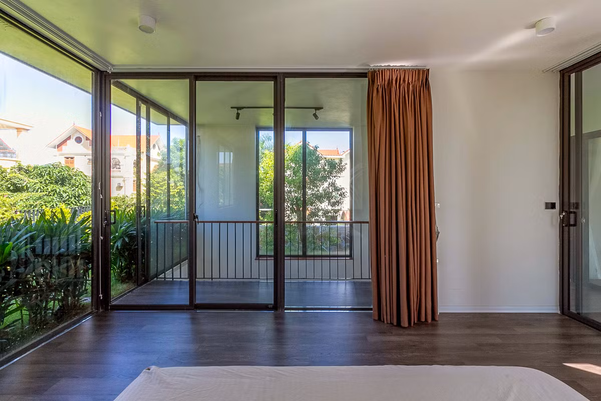 Nhờ cửa kính lớn, gia chủ có thể ngắm khu vườn ngay cả khi ở trong phòng ngủ. Ảnh: HGAA