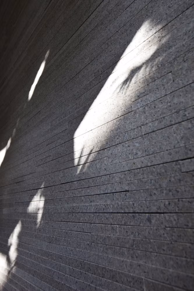 Vào buổi sáng và buổi chiều, ánh nắng xuyên qua lá xanh trên cả hai mặt trước và sau, tạo hiệu ứng bóng đổ đẹp mắt trên các bức tường đá granit. Ảnh: Hiroyuki Oki