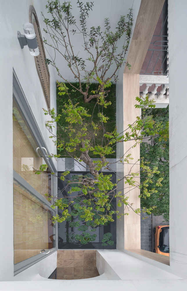 Phía dưới cùng của khu đất, kiến trúc sư cắt một khoảng giếng trời rộng 90cm kéo dài toàn bộ khu đất (11m) để lấy sáng và thông gió cho phòng ngủ, phòng sinh hoạt chung… ở phía sau. Ảnh: Triệu Chiến