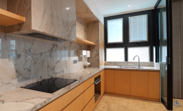 Phòng bếp ngăn với khu vực bàn ăn bằng vách kính lớn. Ảnh chụp màn hình