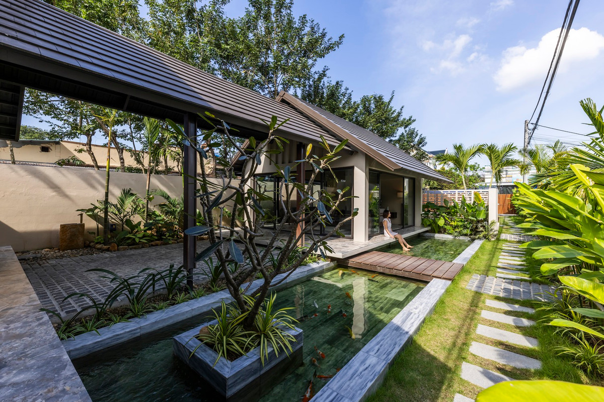 Lối vào nhà qua một hành lang xanh tươi và một lối đi bằng đá tự nhiên và một hồ cá Koi, giúp tăng cường bầu không khí trong lành. Ảnh: Hiroyuki Oki