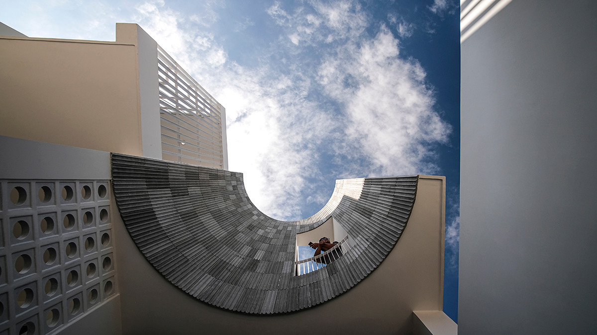 Mặt tiền lớn nhưng hẹp dần về phía sau là thách thức không nhỏ với kiến trúc sư. Để đáp ứng nhu cầu của gia đình, nhóm thiết kế tạo nên những đường cong ở mặt đứng công trình. Ảnh: Nguyên Đinh