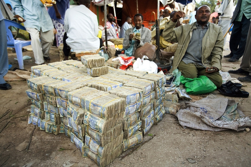 Mỗi người bán như chủ một ngân hàng. Tuy nhiên, thay vì giữ tiền trong két thì người ta bó tiền như rau quả rồi bày la liệt trên sạp bán hàng. Ảnh: Getty