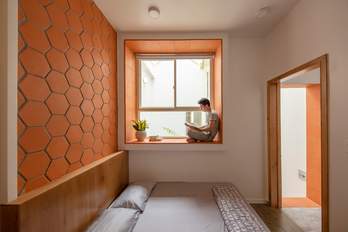 Phòng ngủ của bố mẹ bố trí thêm một ô cửa sổ lớn để ngồi đọc sách và thư giãn hướng ra giếng trời. Ảnh: Thiết Vũ