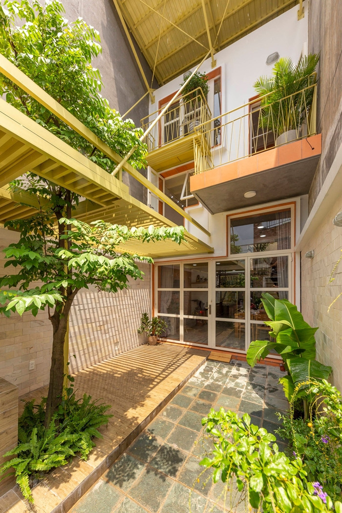 Ngoài hiên nhà, tại khu vực buôn bán, gia chủ trồng cây cao tạo bóng mát cho quầy pha chế và chỗ ngồi của khách. Ảnh: Thiết Vũ