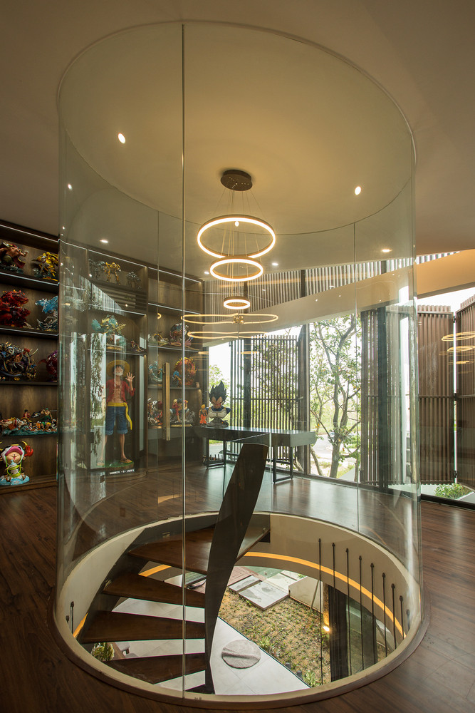 Khu vực cầu thang được bao quanh bởi một khung kính tròn tại trung tâm sảnh tầng 1. Ảnh: 85 Thiết kế