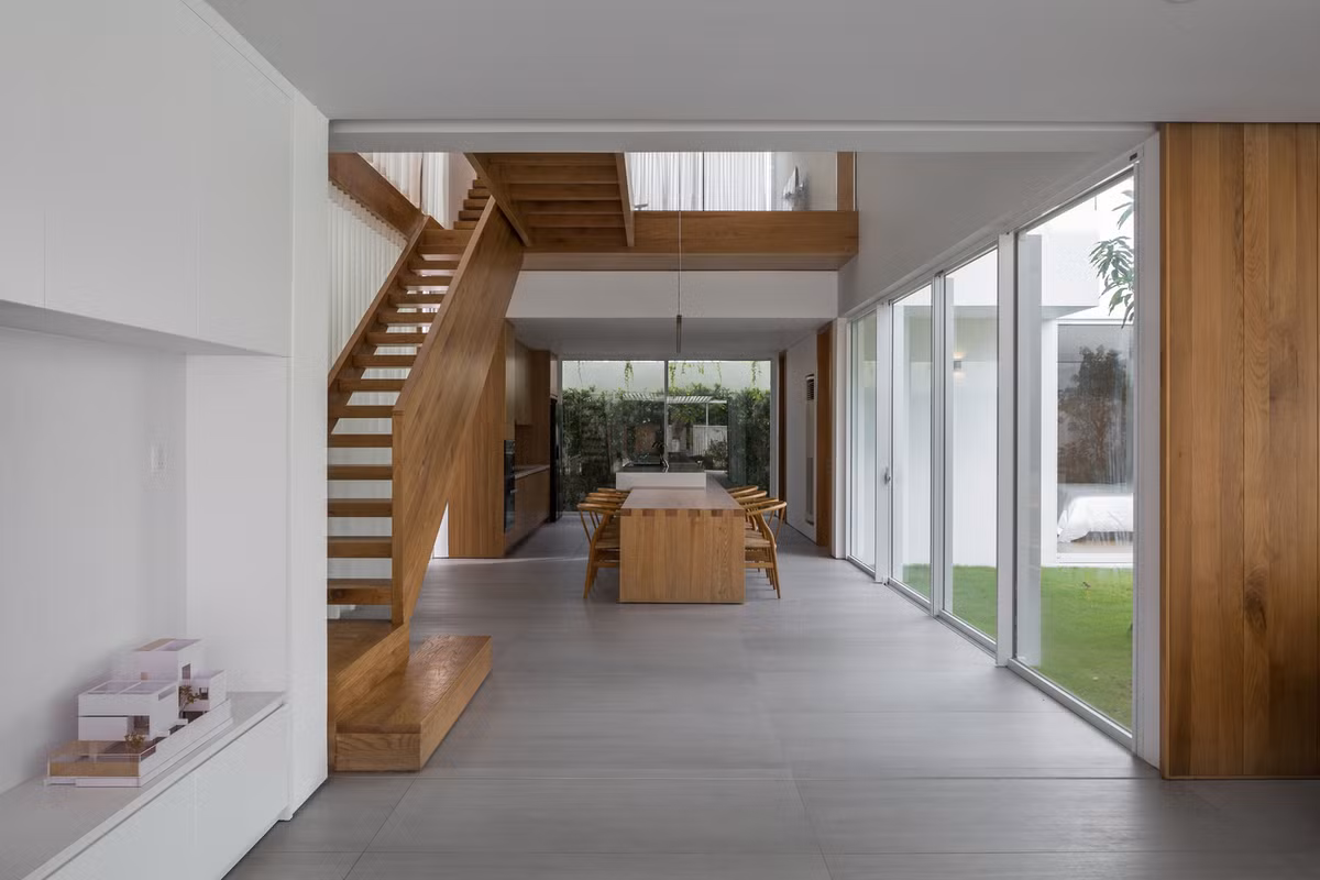 Phòng ăn với không gian giếng trời và hành lang gỗ kết nối phía trên giúp tăng cường sự tương tác. Ảnh: Hoàng Lê