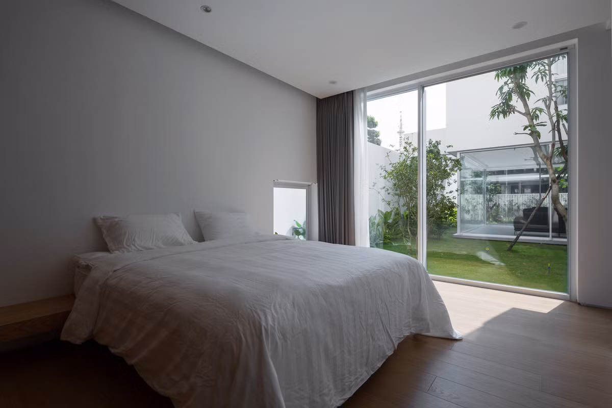 Phòng ngủ tối giản với gam màu trắng chủ đạo, ngập tràn ánh nắng. Ảnh: Hoàng Lê