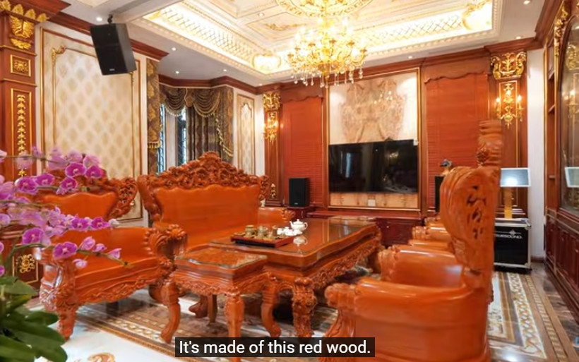 Nổi bật trong phòng khách là bộ bàn ghế gỗ gõ đỏ đồ sộ, chạm trổ cầu kỳ. Ảnh chụp màn hình NhaF