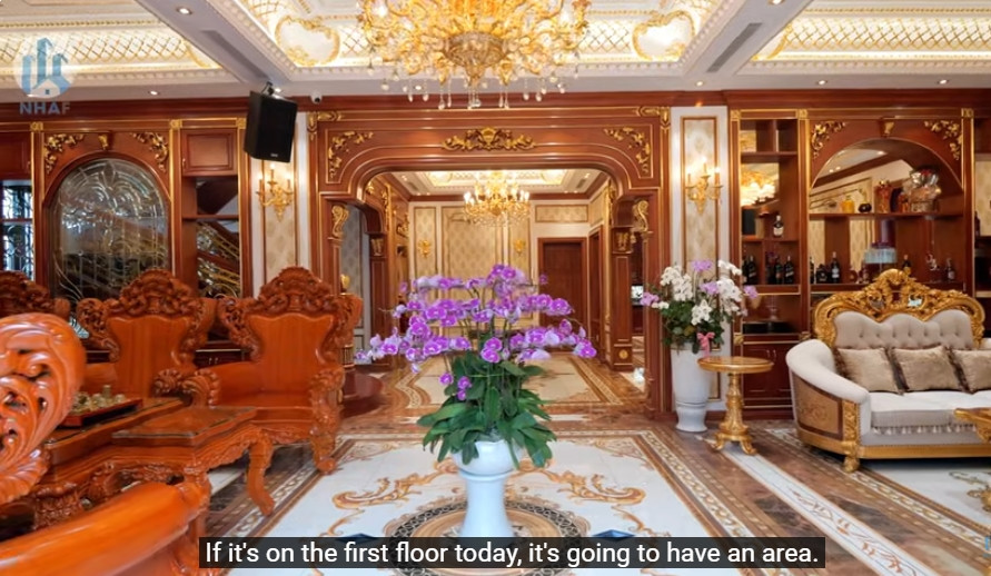 Tầng 1 có diện tích khoảng 210m2, bao gồm không gian sinh hoạt chung như phòng khách, phòng bếp, bàn ăn, khu vực cầu thang bộ, thang máy. Ảnh chụp màn hình NhaF