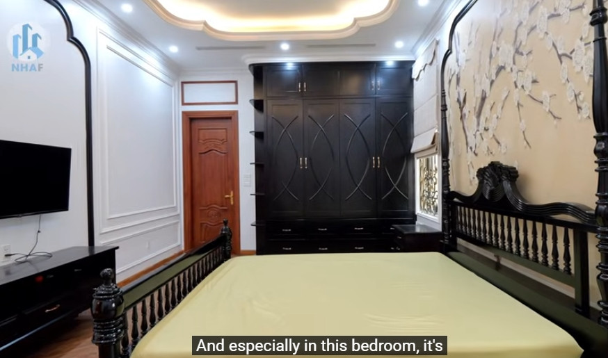  Ngôi nhà có 5 phòng ngủ, trong đó phòng ngủ tại tầng 1 mang phong cách Indochine với tone đen trắng chủ đạo. Ảnh chụp màn hình NhaF