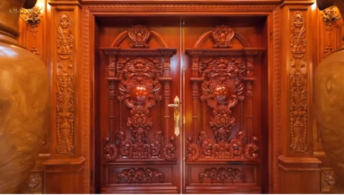 Bên trong, sự giàu có của gia chủ được khoe khéo léo với đầy nội thất, chi tiết gỗ. Cửa nhà bằng cửa gỗ gõ đỏ rất dày. Ảnh chụp màn hình NhaTo