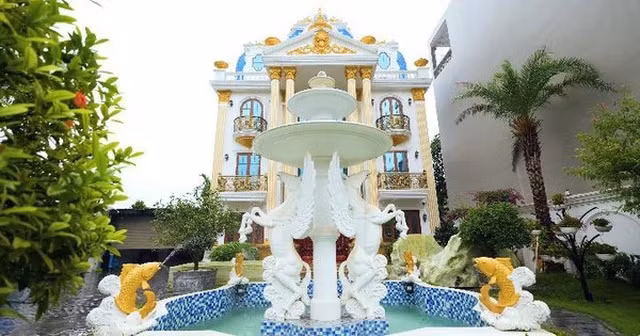 Tòa lâu đài gồm 4 tầng 1 tum, bên ngoài có tháp nước trang trí hình ngựa có cánh, một khu vườn nhỏ để bàn uống nước và gara. Ảnh chụp màn hình NhaTo