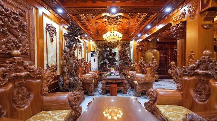 Phòng khách nổi bật với bộ bàn ghế gỗ đồ sộ. Ảnh chụp màn hình NhaTo