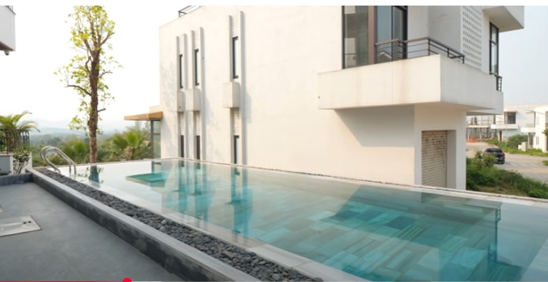 Bên ngoài phòng khách là hồ bơi lớn sở hữu tầm view thung lũng tuyệt đẹp. Ảnh chụp màn hình NhaF