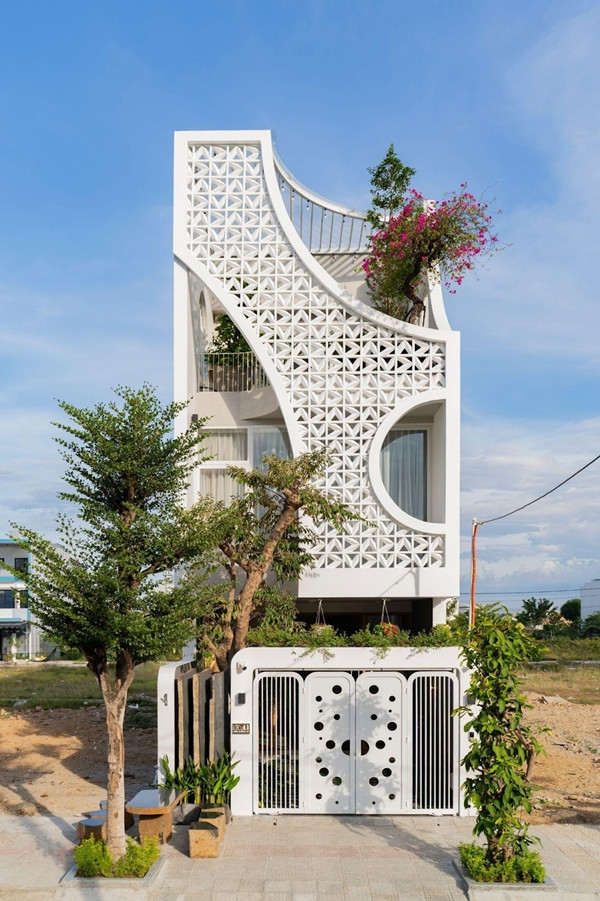 Lấy cảm hứng từ vầng trăng khuyết, mặt tiền được thiết kế những đường cong mềm mại. Ảnh: SBS House