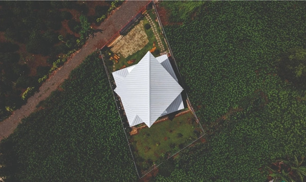 Mái gấp tole trắng không chỉ đóng vai trò chức năng mà còn trở thành điểm nhấn thị giác khi được chiếu sáng. Ảnh: Hiroyuki Oki