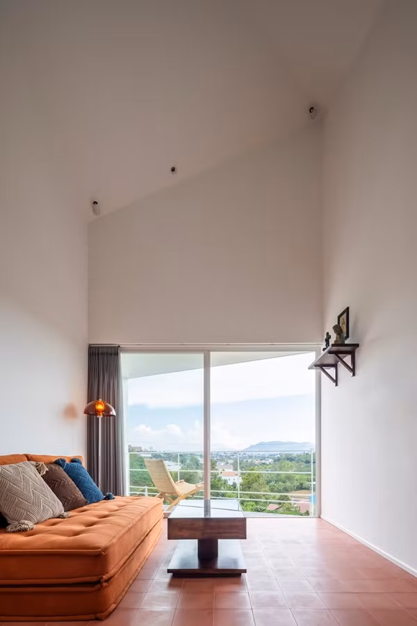 Phòng làm việc nhỏ được bố trí gần cầu thang, với bàn gỗ đơn giản, kệ sách và cửa sổ mở ra phía vườn. Ảnh: Hiroyuki Oki