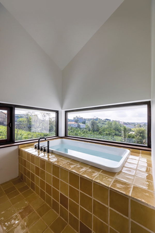 Bồn tắm được đặt ở một góc riêng biệt, hướng thẳng ra ngoài cửa sổ, mang lại những phút giây thư giãn. Ảnh: Hiroyuki Oki