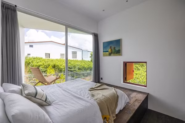 Phòng ngủ chính thiết kế rộng rãi với ban công lớn nhìn ra khu vườn. Ảnh: Hiroyuki Oki