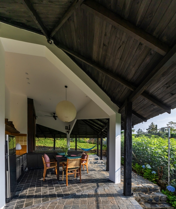 Mái hiên xà thấp mở rộng không gian sinh hoạt, đồng thời đóng vai trò như một lớp bảo vệ mềm mại, điều tiết ánh sáng và mưa. Ảnh: Hiroyuki Oki