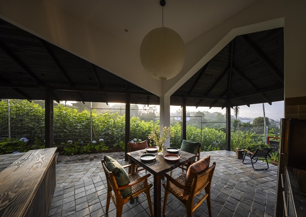 Bếp liền kề với phòng khách, mở ra sân vườn qua cửa kính trượt. Ảnh: Hiroyuki Oki