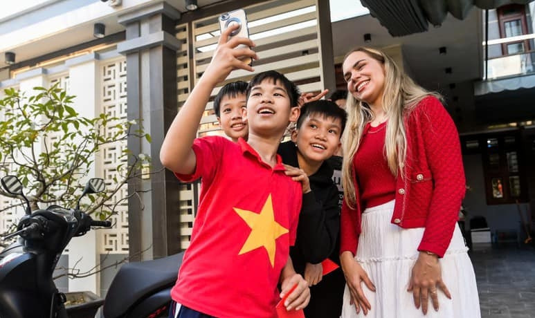 Vợ tiền đạo Xuân Son vui vẻ chụp ảnh cùng người hâm mộ. Ảnh: Nhân dân