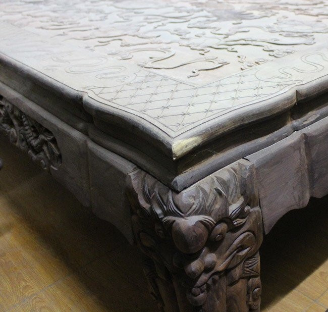 Mặt bàn chạm khắc tinh xảo. Bốn chân bàn chạm khắc bằng bốn đầu rồng. Ảnh: Người đưa tin