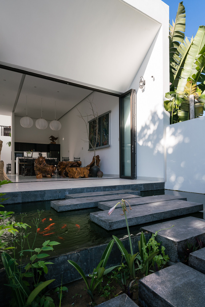 Hồ cá là bước đệm từ ngoài vào phòng khách, đem lại không khí mát mẻ cho căn nhà ở mảnh đất miền Trung nắng nóng quanh năm. Ảnh: Quang Trần