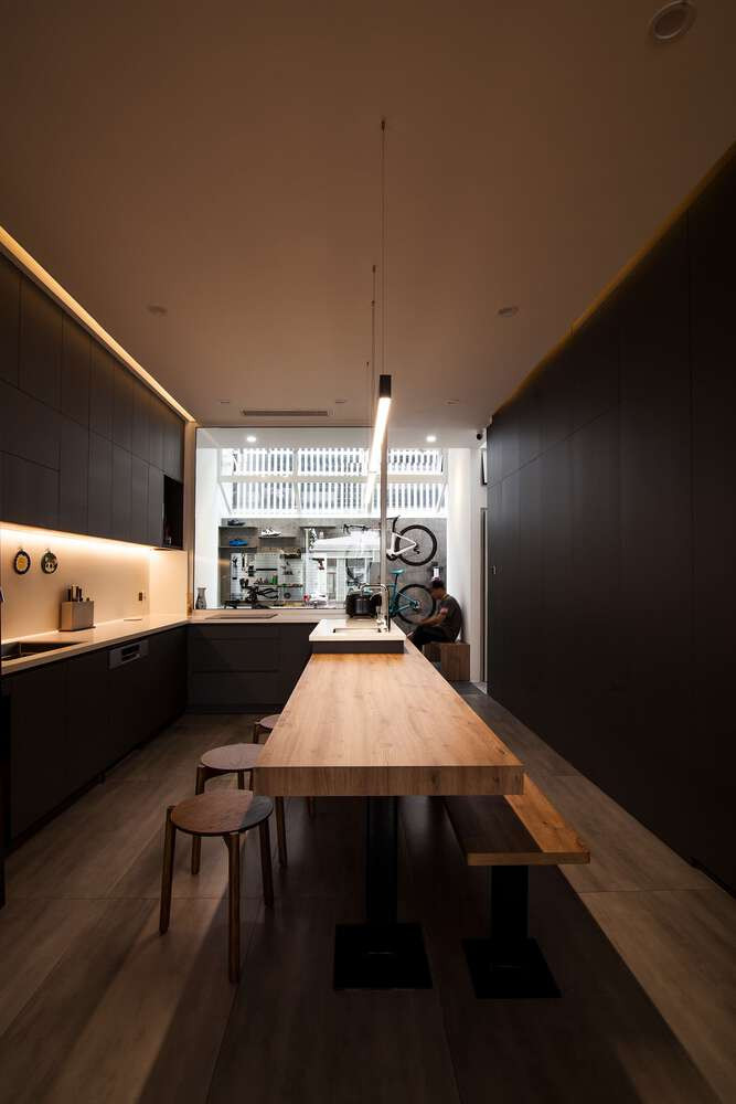 Xuyên suốt tầng 1 là phòng khách và nhà bếp liên hoàn, sử dụng tông xám đen mang lại cảm giác hiện đại. Ảnh: DinhR