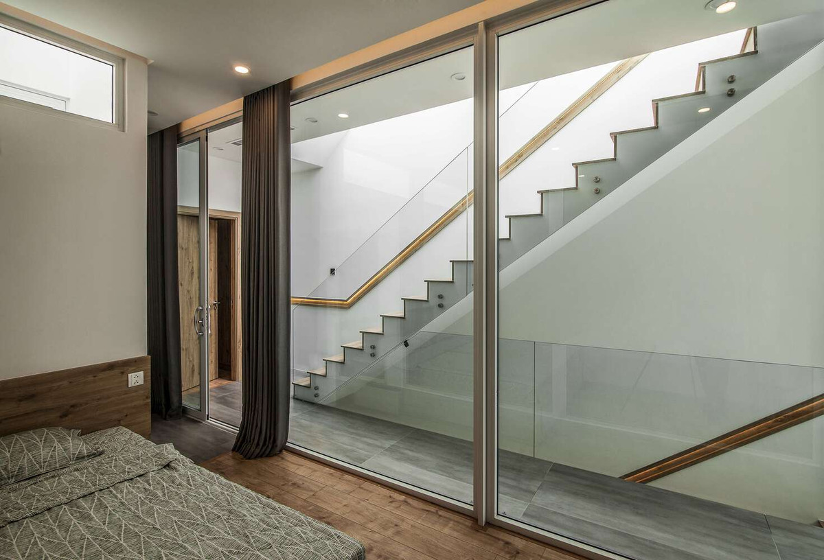 Cầu thang được thiết kế kín đáo, tạo sự thông suốt trong không gian khách bếp. Ảnh: DinhR