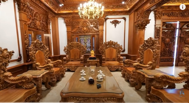 Phòng khách nổi bật với bộ bàn ghế bằng gỗ lim khổng lồ. Ảnh chụp màn hình