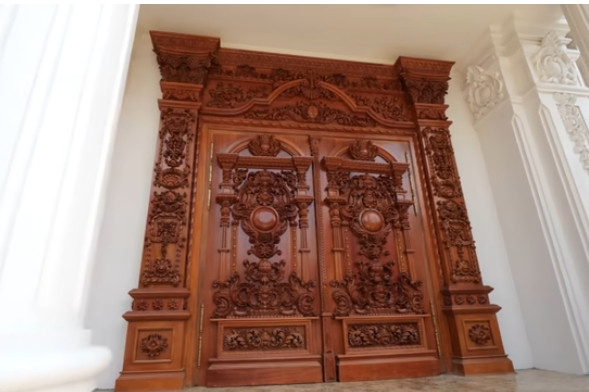 Sảnh chính ngôi nhà được ốp đá nhập khẩu. Cửa vào bằng gỗ lim nguyên khối, được chạm khắc tỉ mỉ. Ảnh chụp màn hình