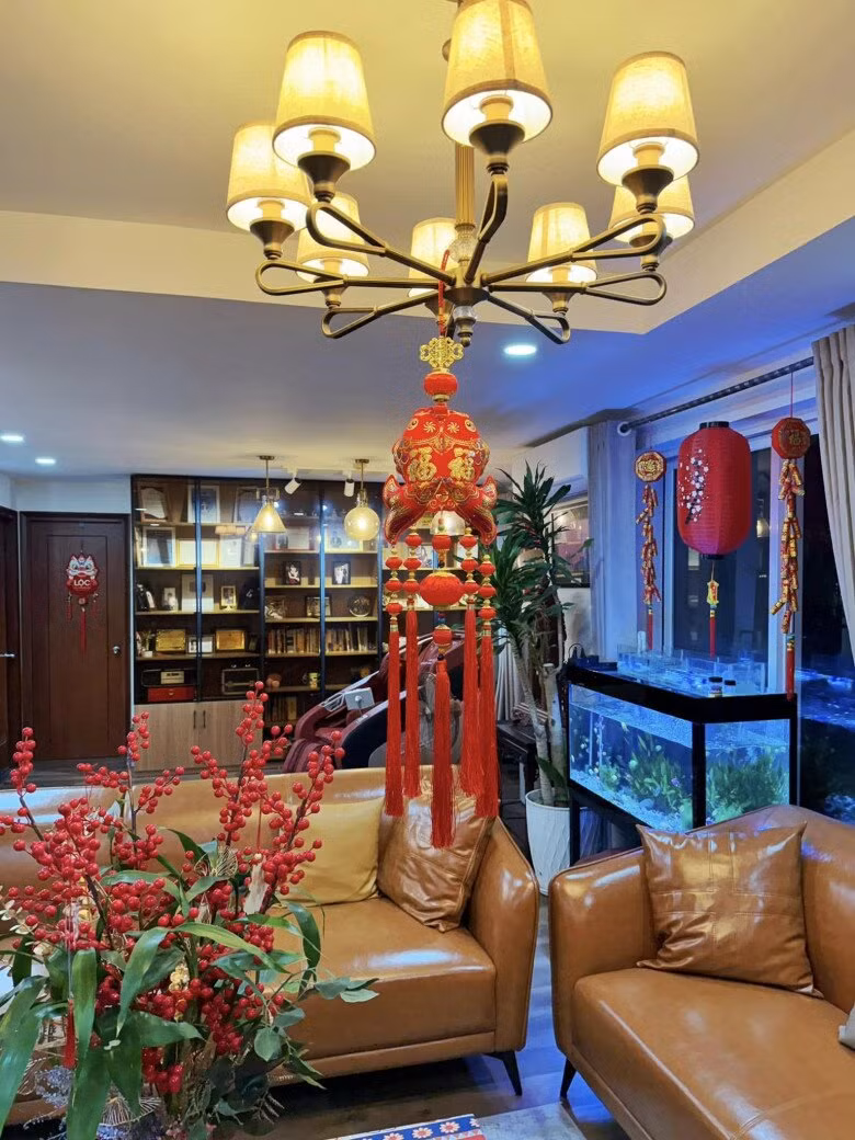 Đèn chùm giữa phòng khách được trang trí thêm một chiếc đèn lồng đỏ lớn. Ảnh: FB Nguyên Khang