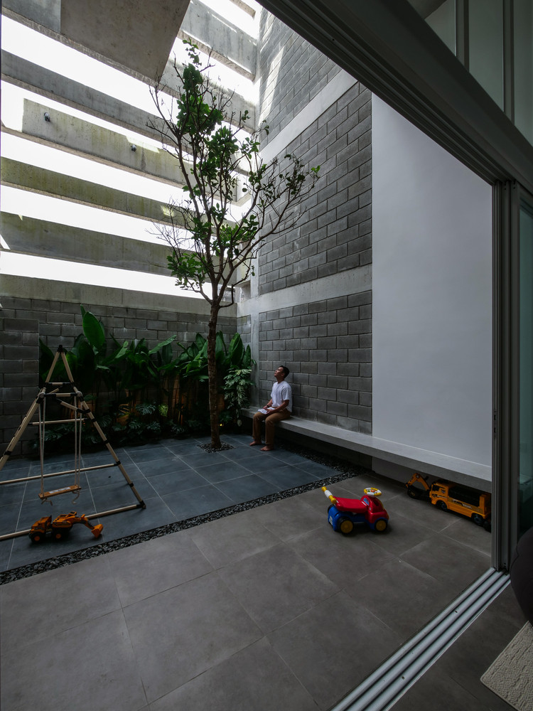 Tầng trệt mở ra không gian rộng rãi với bếp liền kề, kết nối trực tiếp với sân sau (là trái tim và lá phổi của ngôi nhà). Ảnh: DinhR