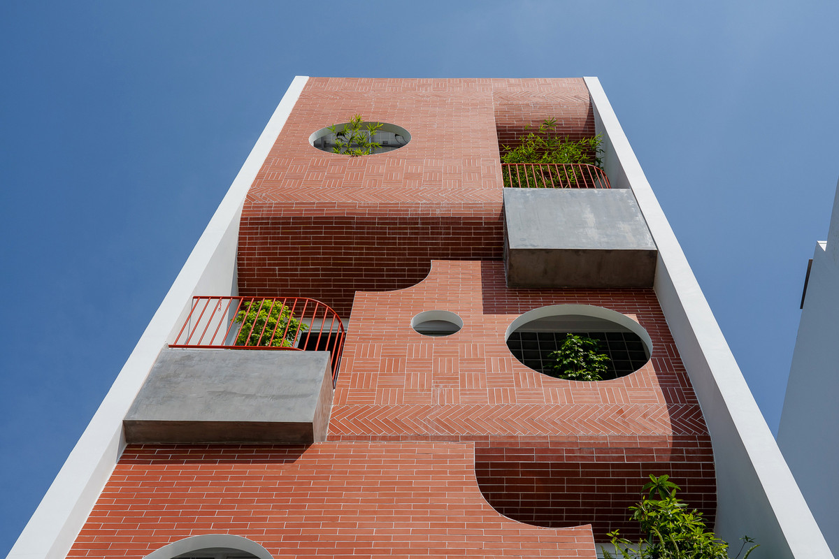 Ở mặt tiền, kiến trúc sư sử dụng các bức tường gạch nung vừa tạo điểm nhấn, vừa ngăn nắng nóng chiếu trực tiếp vào nhà. Ảnh: Quang Trần