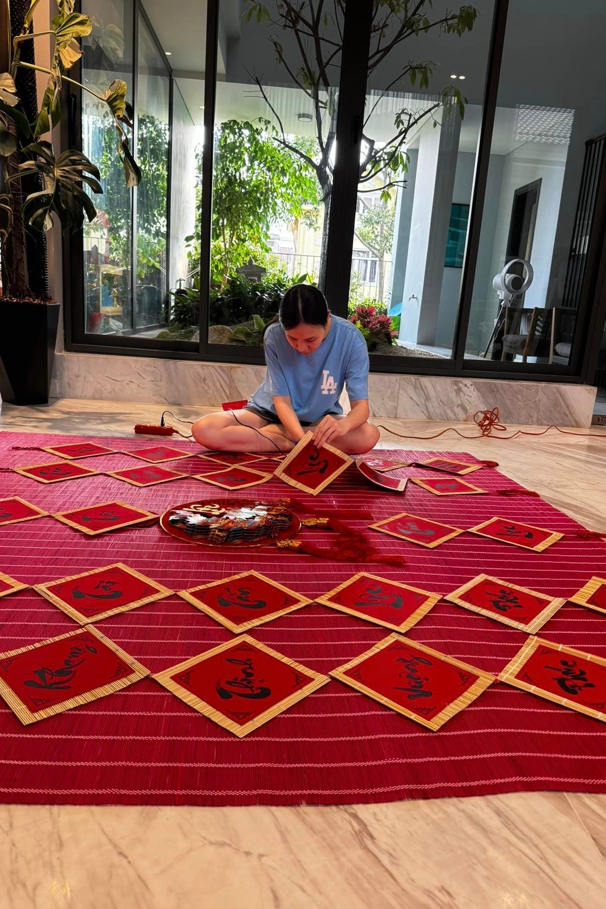 Người đẹp tự làm một số tiểu cảnh như câu đối đỏ, đồng tiền vàng, bánh chưng, bánh tét, dưa hấu... mừng năm mới. Ảnh: FBNV