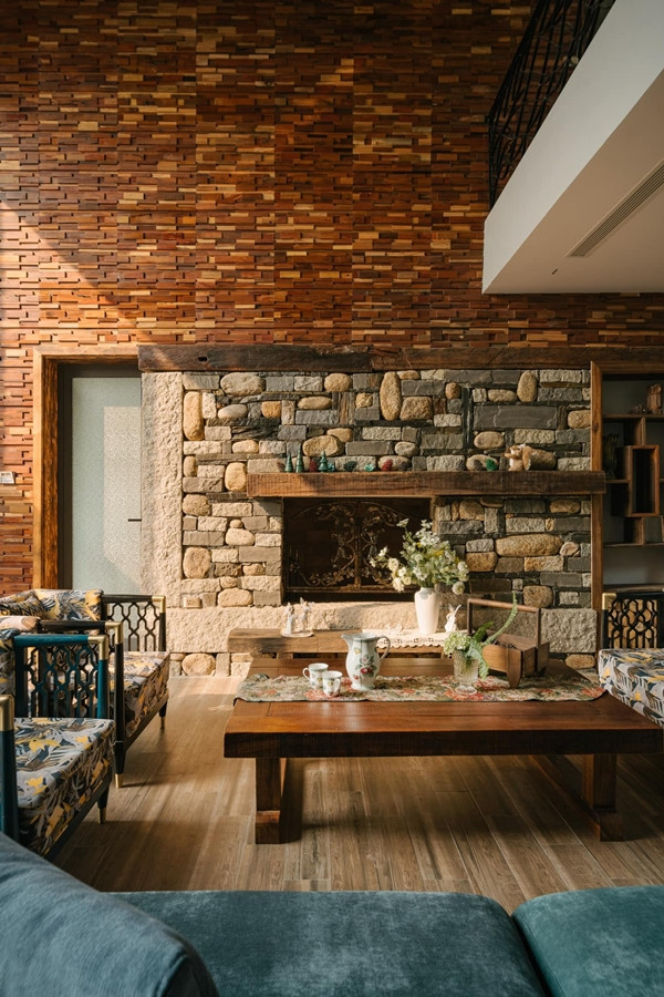 Điểm nhấn trong phòng khách là lò sưởi ốp đá tự nhiên, tường ốp gỗ và decor theo phong cách vintage châu Âu. Ảnh: Baophunuthudo